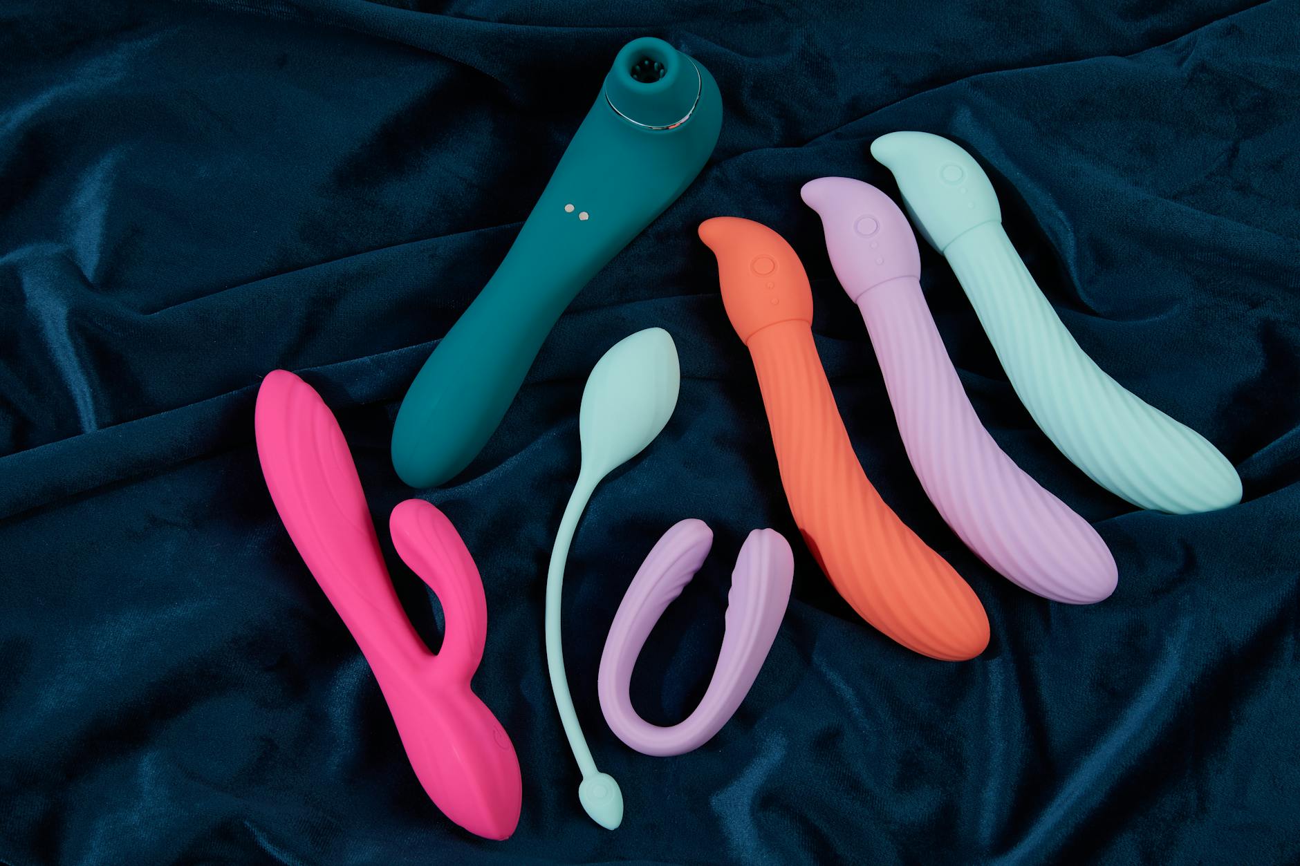 A couple standing together indoors holding a blue vibrator, symbolizing modern intimacy and partnership