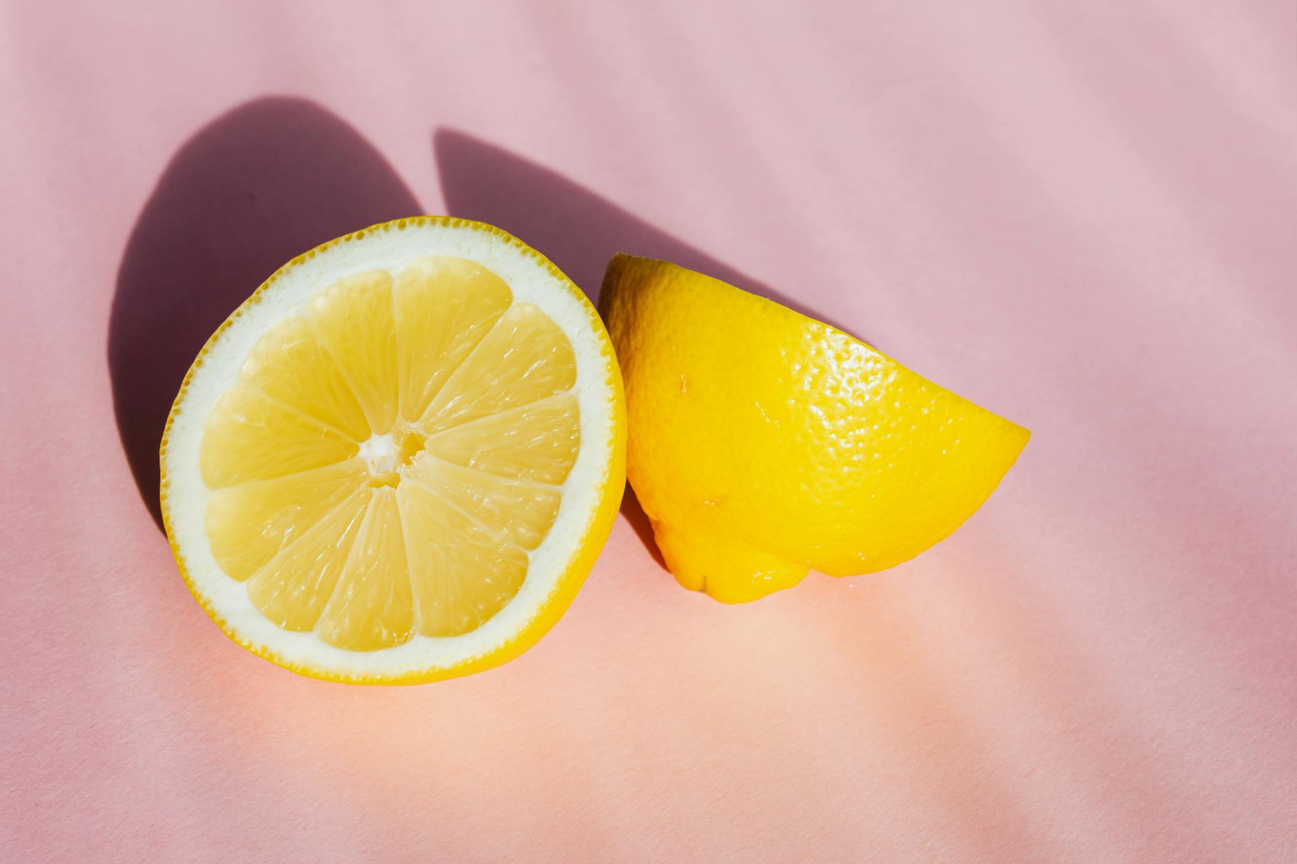Fresh lemon halves on a pink background, symbolizing renewal and sensitivity shifts