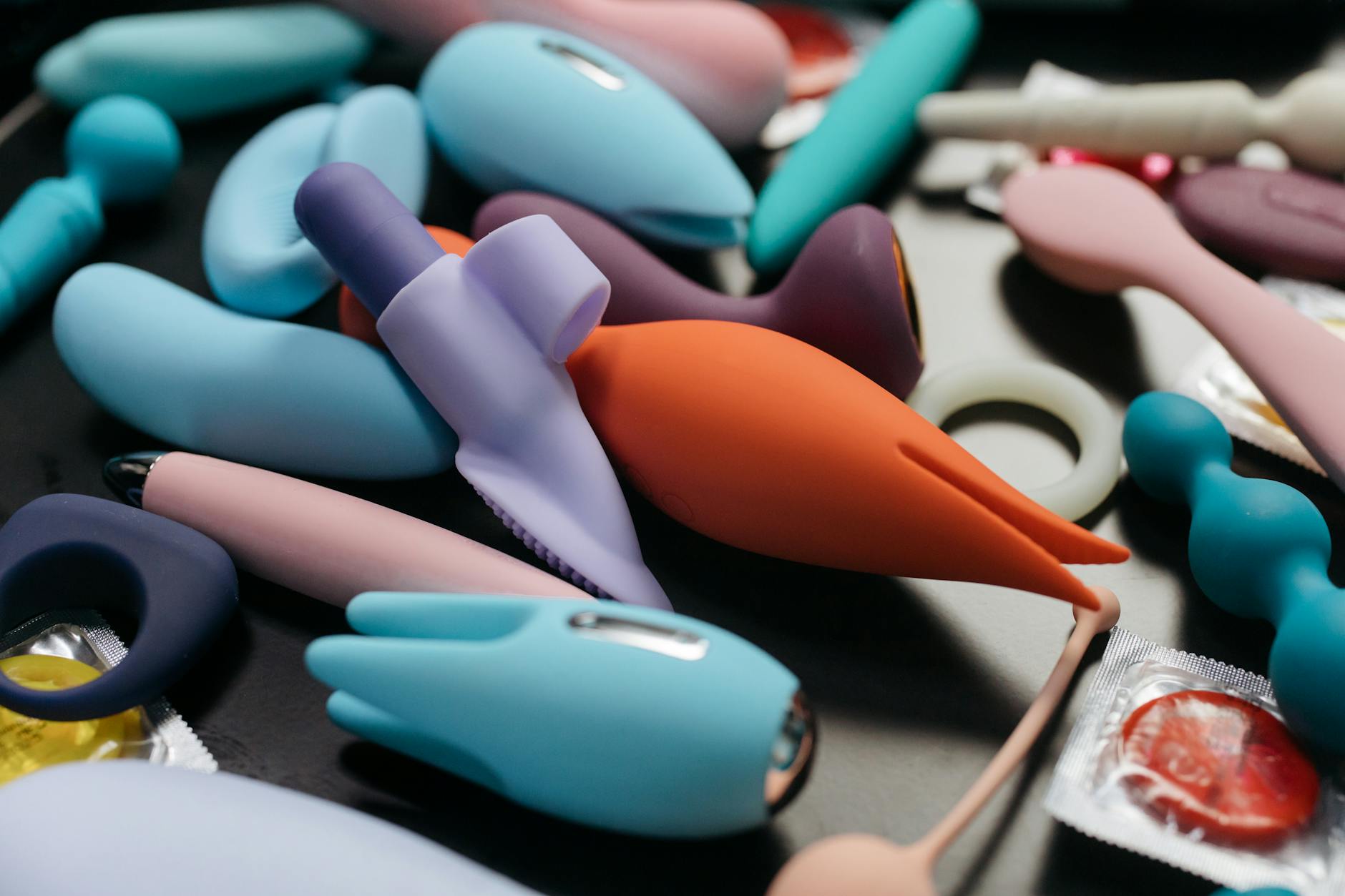 Young couple standing together indoors, holding a blue vibrator, symbolizing modern intimacy